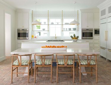 Contemporary white kitchen with an island stovetop designed by Jenkins Interiors.