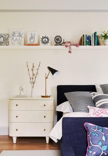 Stuffed Animal Storage in Kid's room with white dresser and long shelf to display art, books and stuffed animals, designed by Katie Rosenfeld.