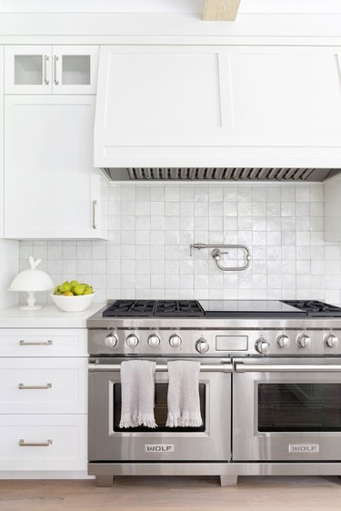 stainless steel double oven and gas stovetop in white kitchen