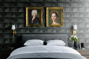 black bedroom with gold accents and shelf-lined wallpaper