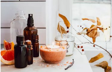 Candles and essential oils bottles on counter in autumnal colors