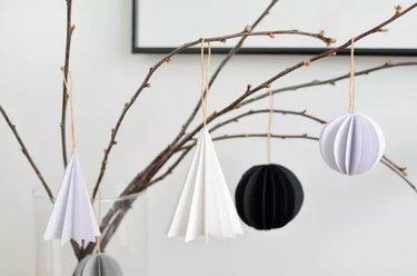 Folded paper ornaments hanging on branch