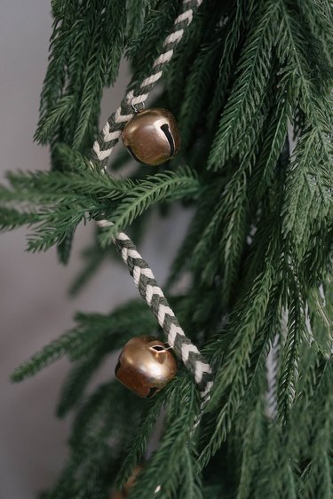 DIY jingle bell garland strung in a Christmas tree