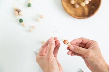 Putting wood and clay beads onto jewelry wire