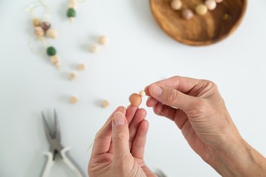 Putting wood and clay beads onto jewelry wire