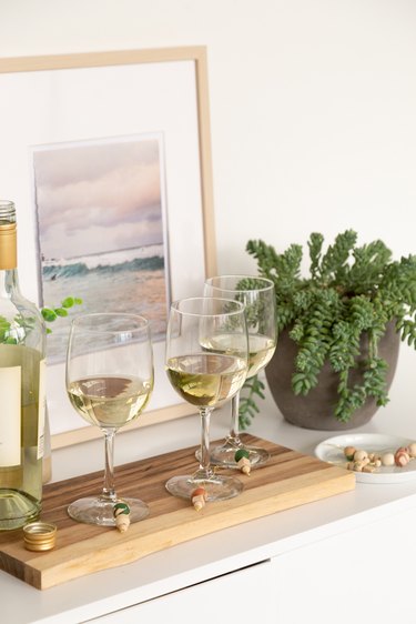 Wine glasses with clay and wood wine charms on display