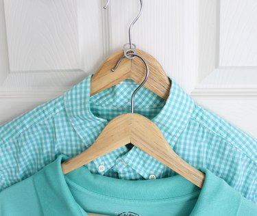 Two shirts on hangers connected by a soda can pull tab.