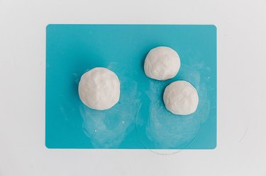 Cut the round clay form in half to create two small half spheres.