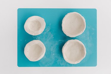 Form your pinch pot by spinning the sphere and squeezing the clay.