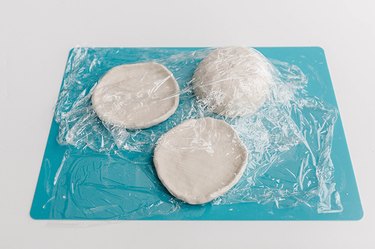 Cover the air-dry clay forms with plastic wrap.