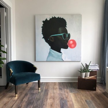 sitting area with jewel-toned chair and large artwork on wall