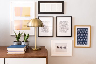 gallery wall and console table with brass lamp