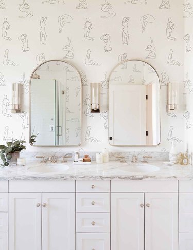 bathroom space with double mirrors and minimalist nude figures wallpaper