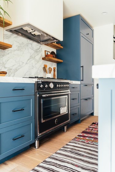 black and silver new stove in blue and white kitchen