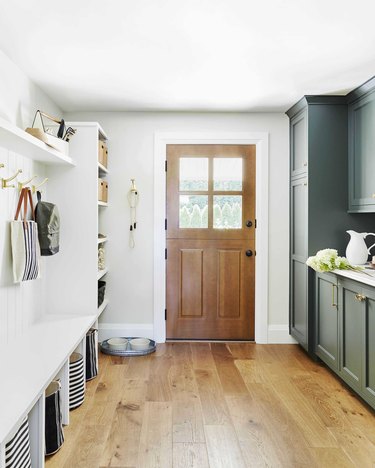 forest green and white mudroom storage with pine floors