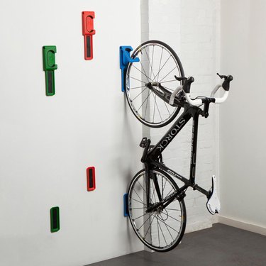red, green, and blue bike storage hooks holding a bicycle