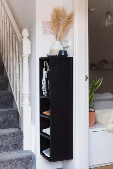 slim wall-mounted shelving unit used for entryway shoe storage