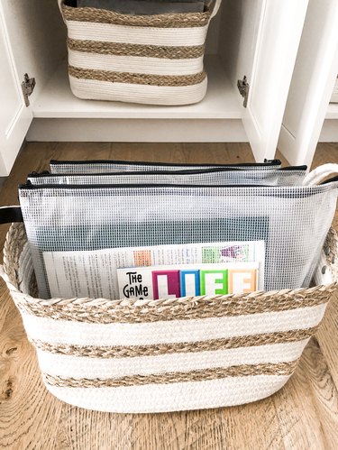 board game storage in zipped pouches in a basket