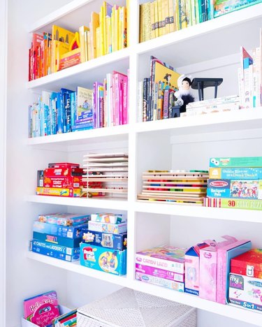 color coded bookcase with board game storage