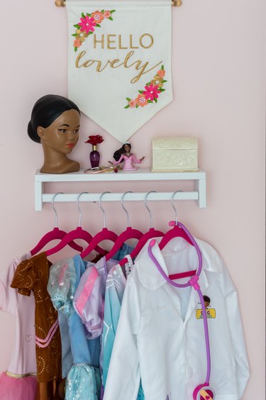 Kids' room organization with pink walls and dress-up area