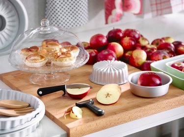 kitchen scene with fruit and knives and cake stand