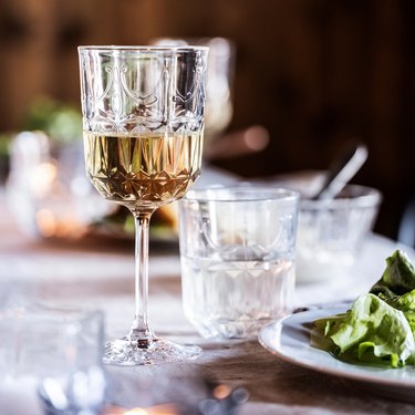 wine glass on table with salad nearby
