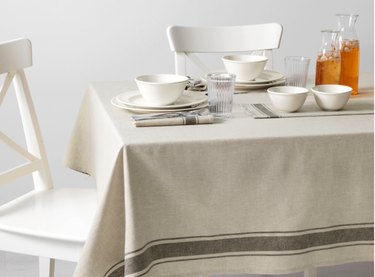 dining scene with white chairs and off-white tablecloth