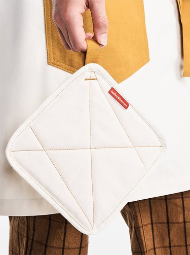 person holding potholder in hand with contrast-stitch pattern