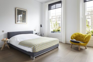 The master bedroom features oak floors and a whimsical Finn Juhl Pelican armchair.