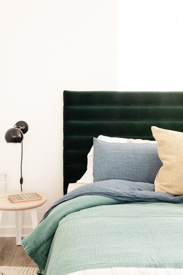 Layered bed with upholstered headboard and Schoolhouse electric bedside sconce