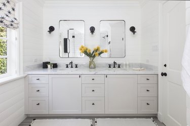 Restoration Hardware mirrors and Schoolhouse Electric sconces accent the children's bathroom.