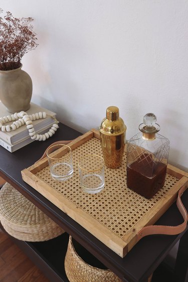 DIY cane webbing tray on table with cocktail shaker, decanter and glasses