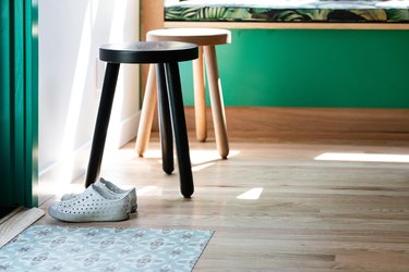 Shoes by stools on wood floor by door