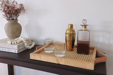 DIY cane webbing tray on table with cocktail shaker, decanter and glasses