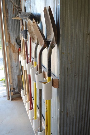 DIY garage organization idea with tools and shovels on pvc pipe stand
