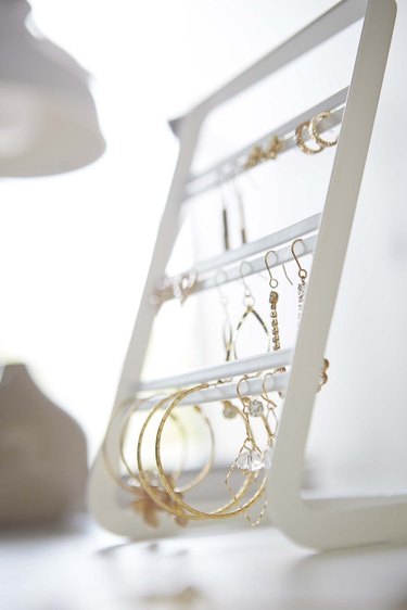 Earring Storage with White jewelry organizer with gold earrings.