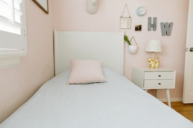 Kid's Room Organization Guide in pink girls room with white nightstand