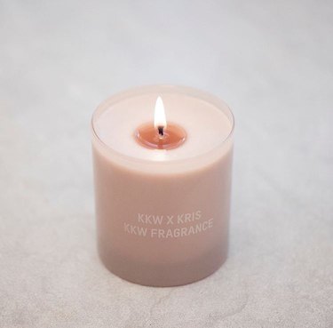 kkw x kris candle burning on a beige table