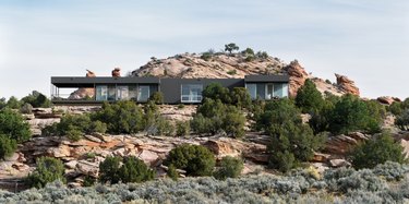 black contemporary ranch home set amongst red rocks