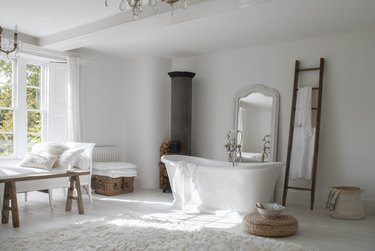 Farmhouse bathroom storage designed by White & Faded with baskets and tub