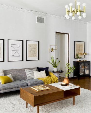 living room space with gray couch and framed artwork on the wall