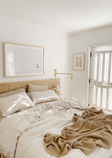 Sylvia Tribel  bedroom with IKEA headboard and brass wall sconces