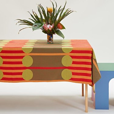 table with plant and colorful, patterned tablecloth