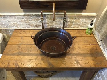 copper industrial bathroom sink on wood counter