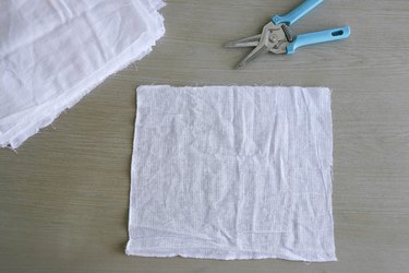 Cutting 12-inch squares of birdseye fabric