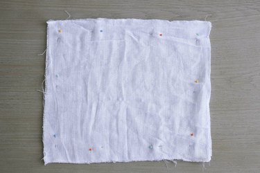 Two fabric squares pinned together