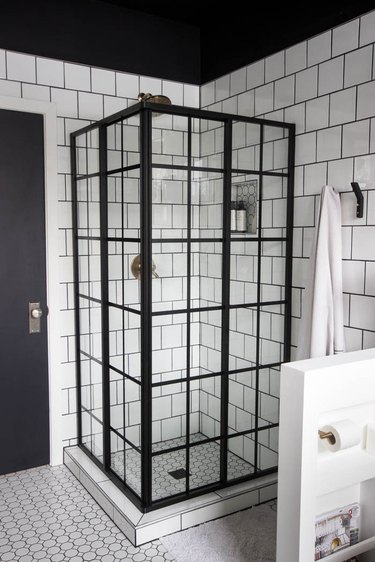 Corner shower with white tile and black industrial linear detailing