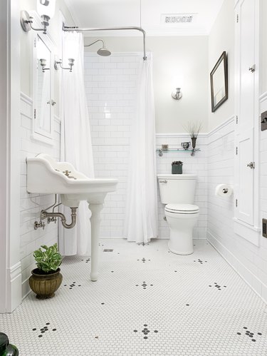 Corner shower with white tile walls and two shower curtains