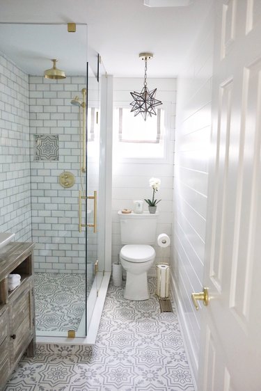 Corner shower with subway tile walls and brass fixtures