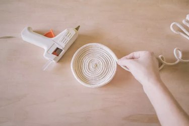hand making bowl using rope and glue gun